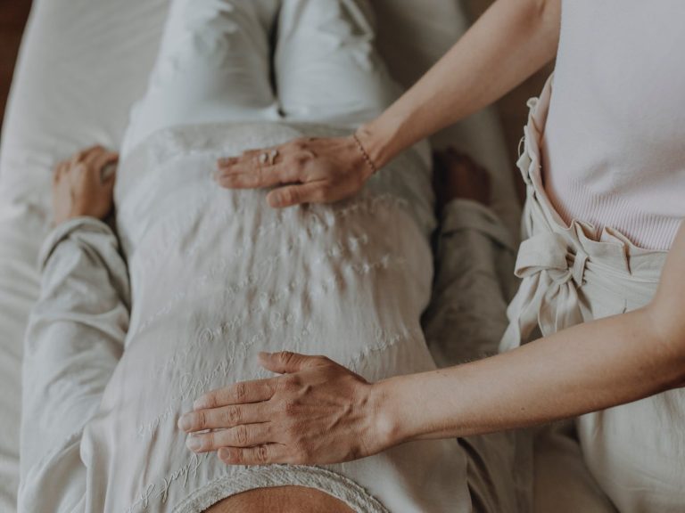 Klangschalenmeditation Kristallklangschale im Einsatz bei einer Meditation mit einer Frau die unter der Klangschale liegt und so den Sound empfängt